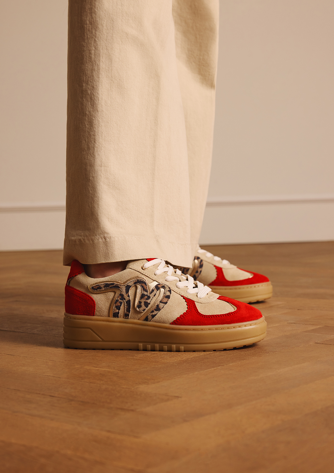 Beige suède sneakers met rode details