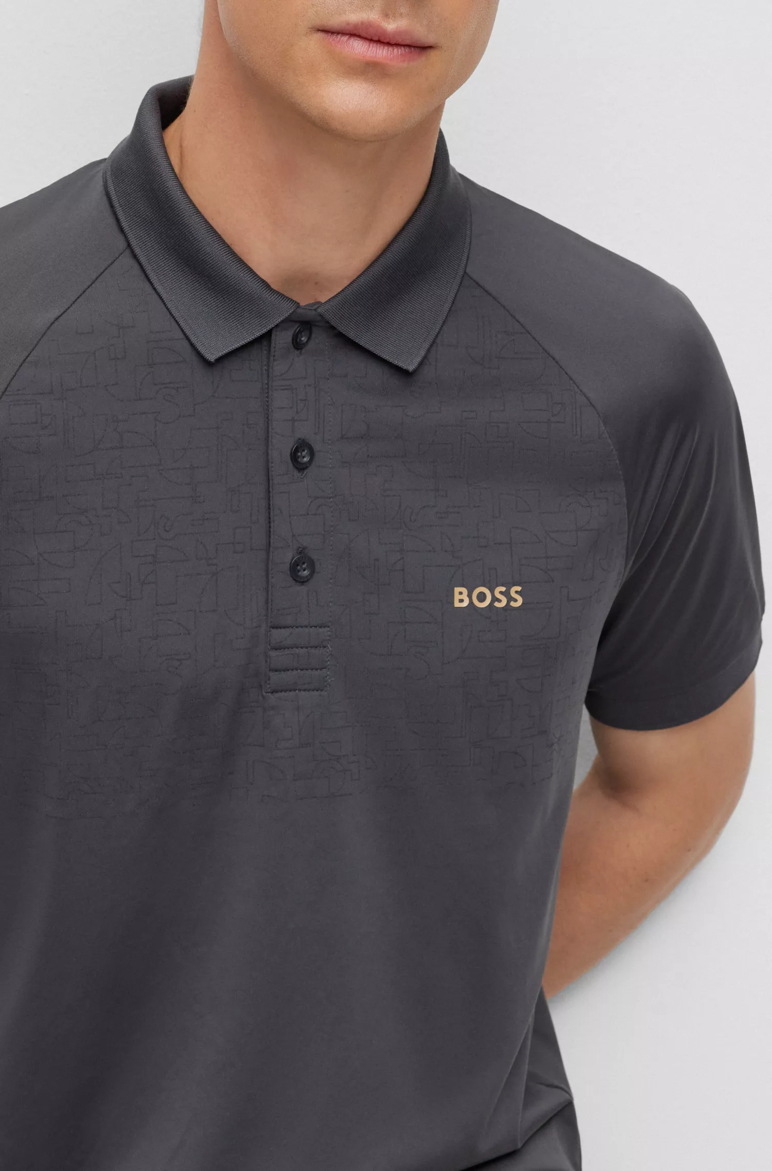 Camisa polo BOSS verde, corte slim, com padrão refletivo decorativo.