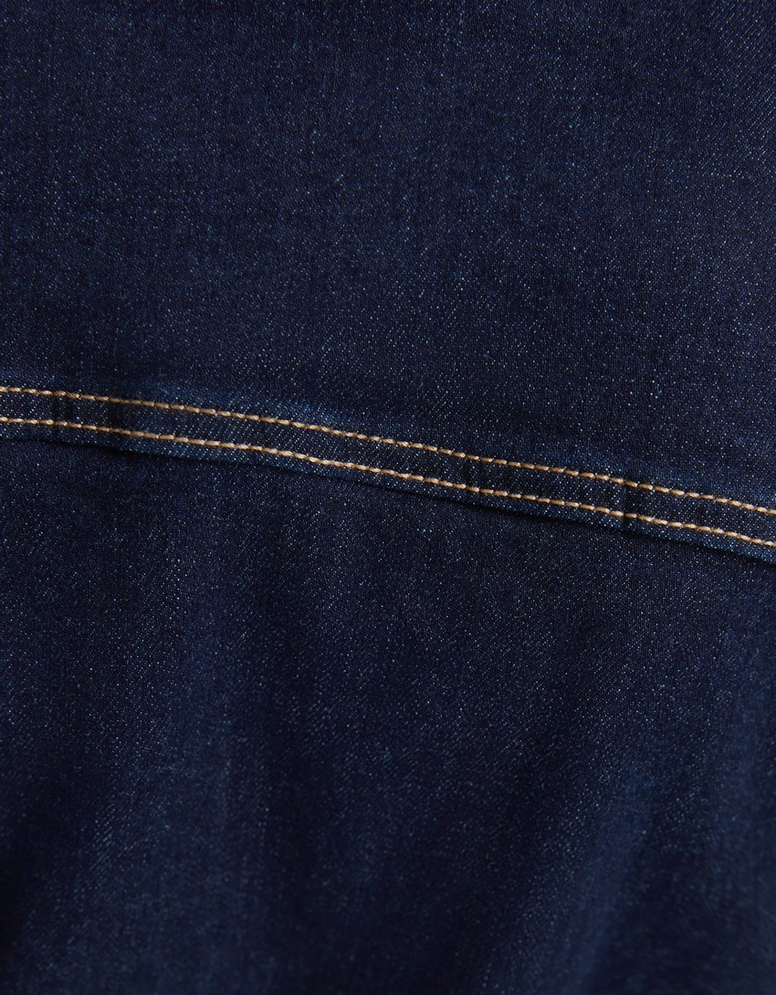 Macacão jeans comprido com mangas compridas e zíper.