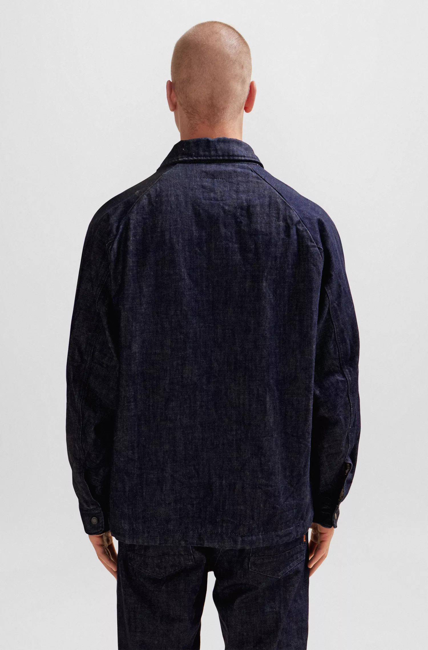 Jaqueta BOSS com forro xadrez laranja em denim azul rígido com efeito amassado.