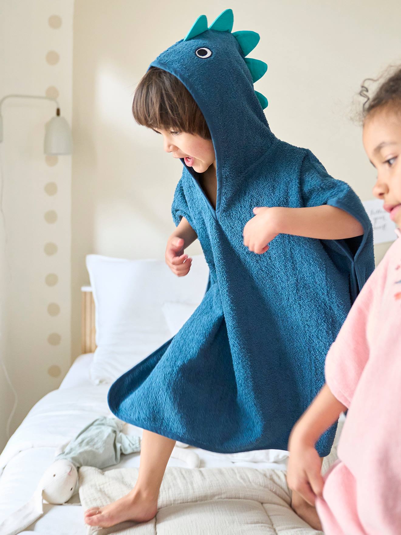 Poncho de banho infantil com estampa de dinossauro, azul médio, liso com detalhes.