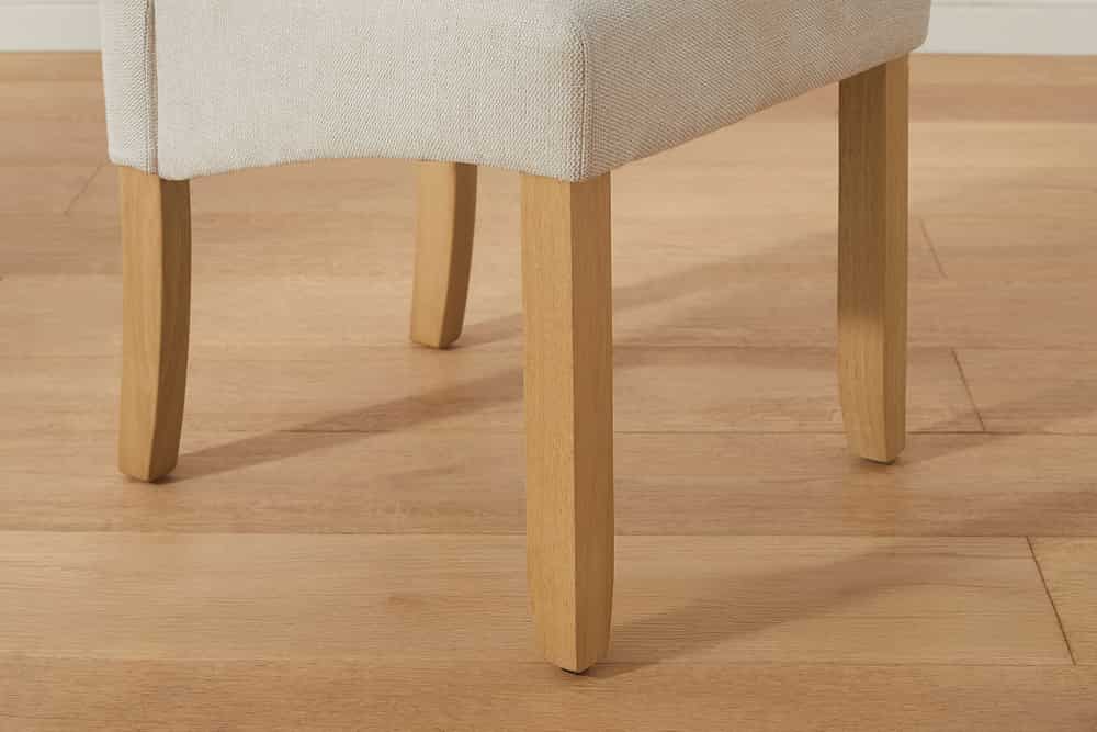 Design Stuhl CASA beige Strukturstoff Massivholzbeine mit Zierknöpfen und Nackenrolle