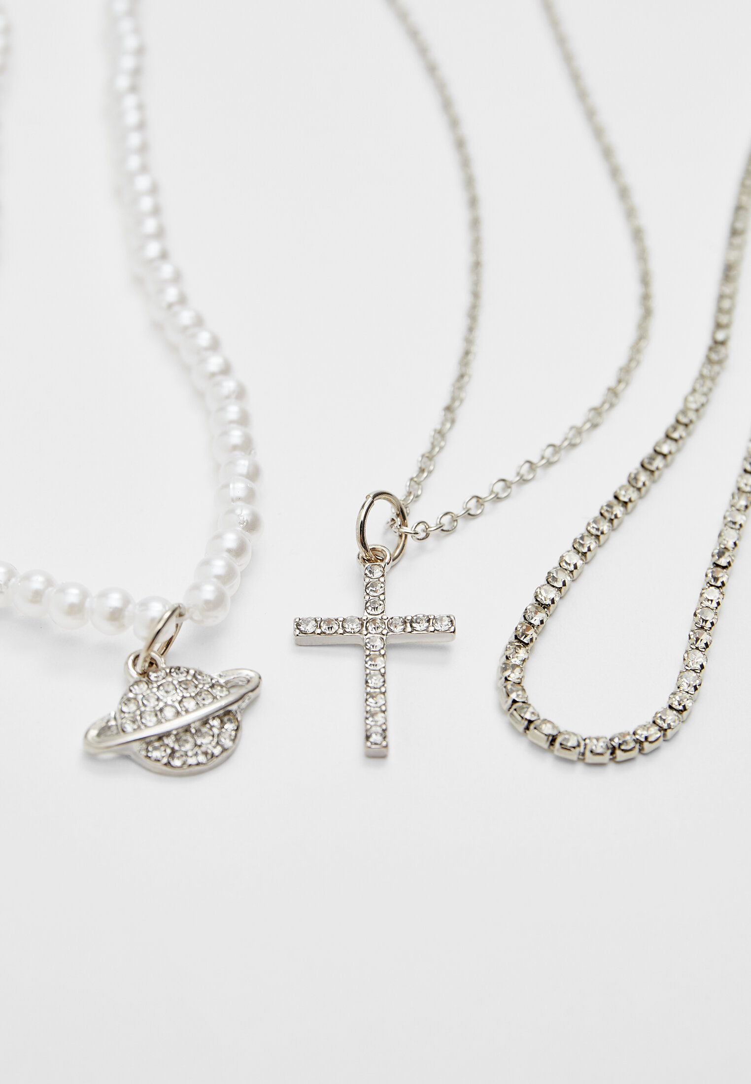 Conjunto de 4 colares com pingentes de cruz e planeta cravejados de strass.