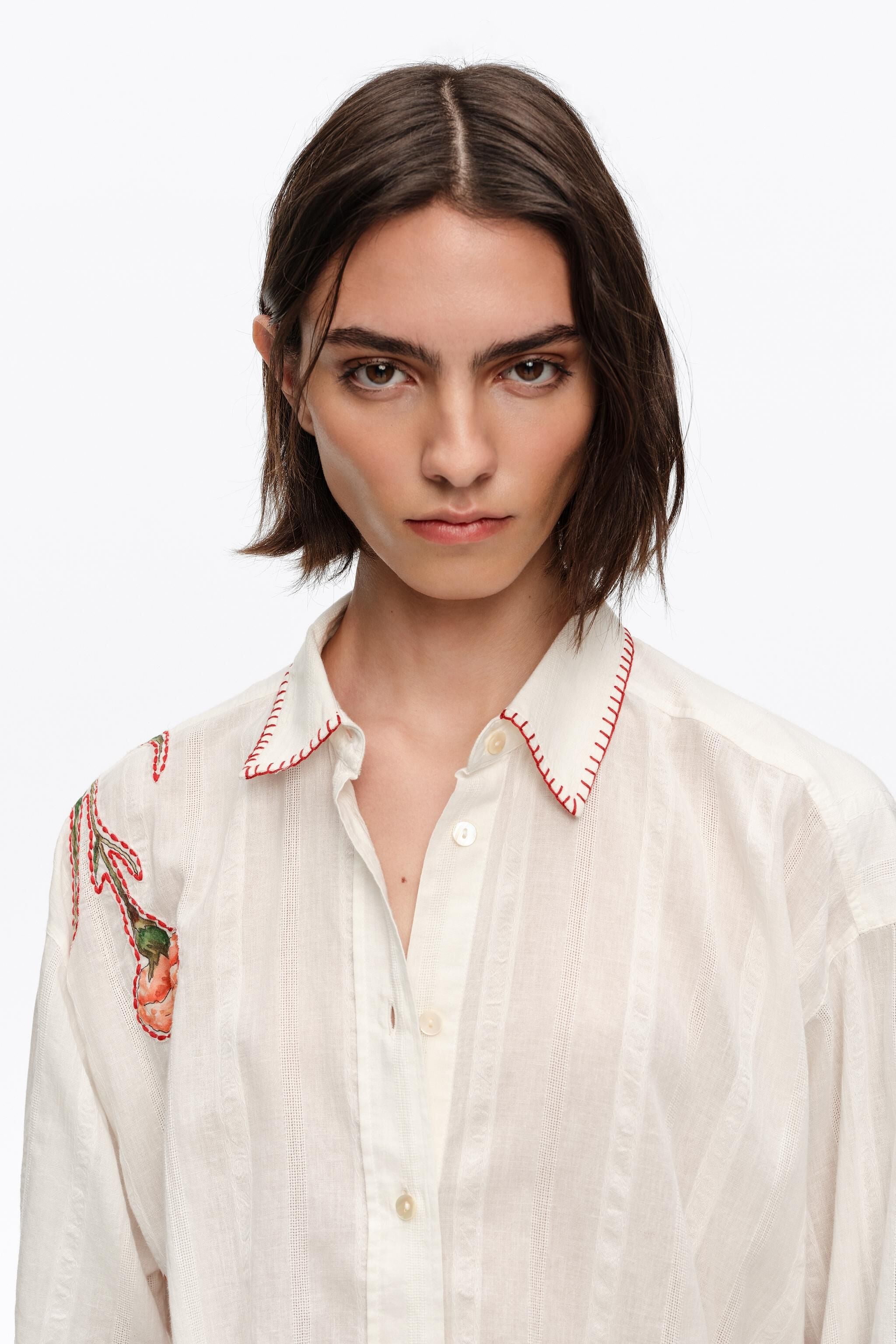 Camisa de algodão cor marfim com costuras e estampas.