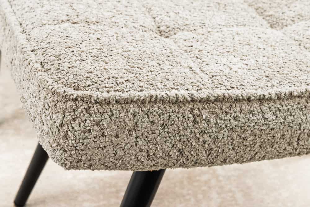 Moderner Hocker SCANDINAVIA champagner greige Bouclé schwarze Metallbeine Fußhocker
