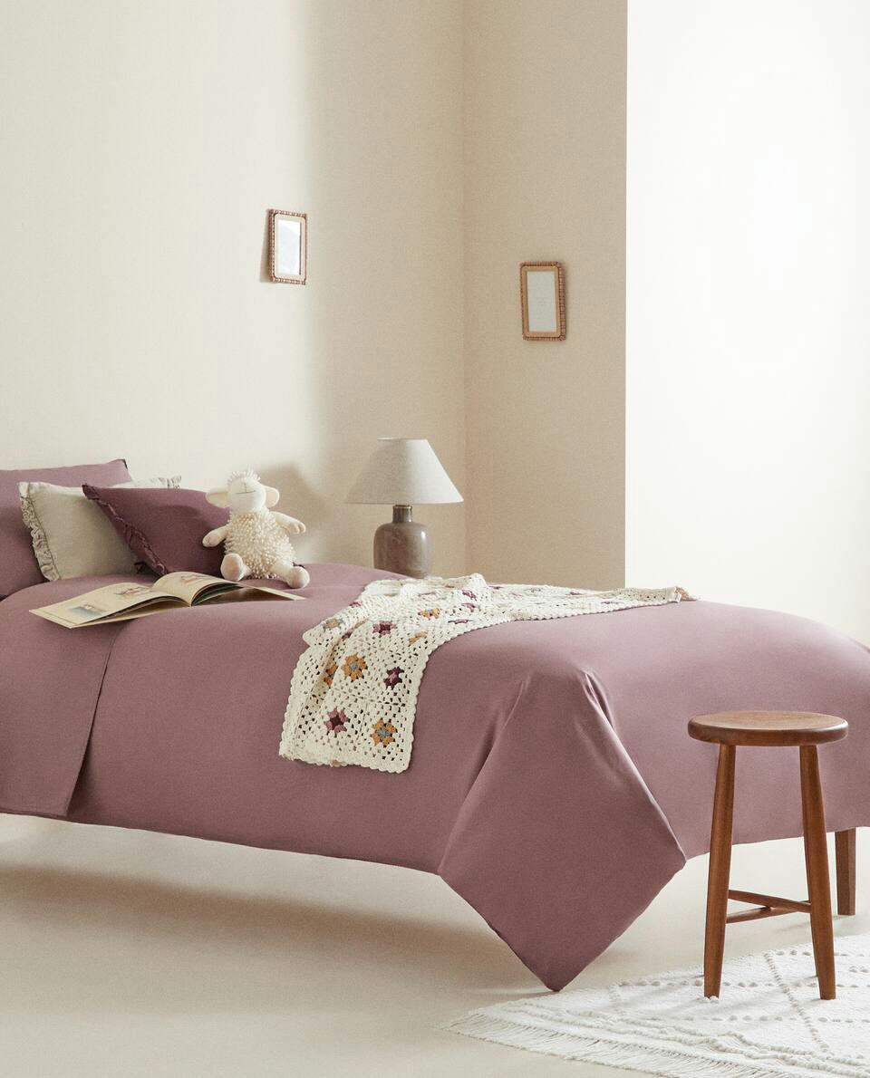 Lençol de algodão infantil com elástico e costura decorativa.