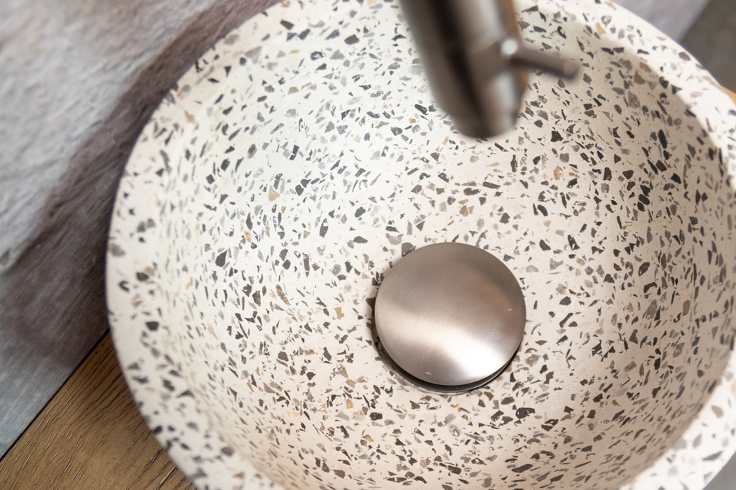 Saniclear Seba fonteinset met bruin eiken plank, zwart-witte terrazzo waskom en verouderd ijzer kraan voor in het toilet