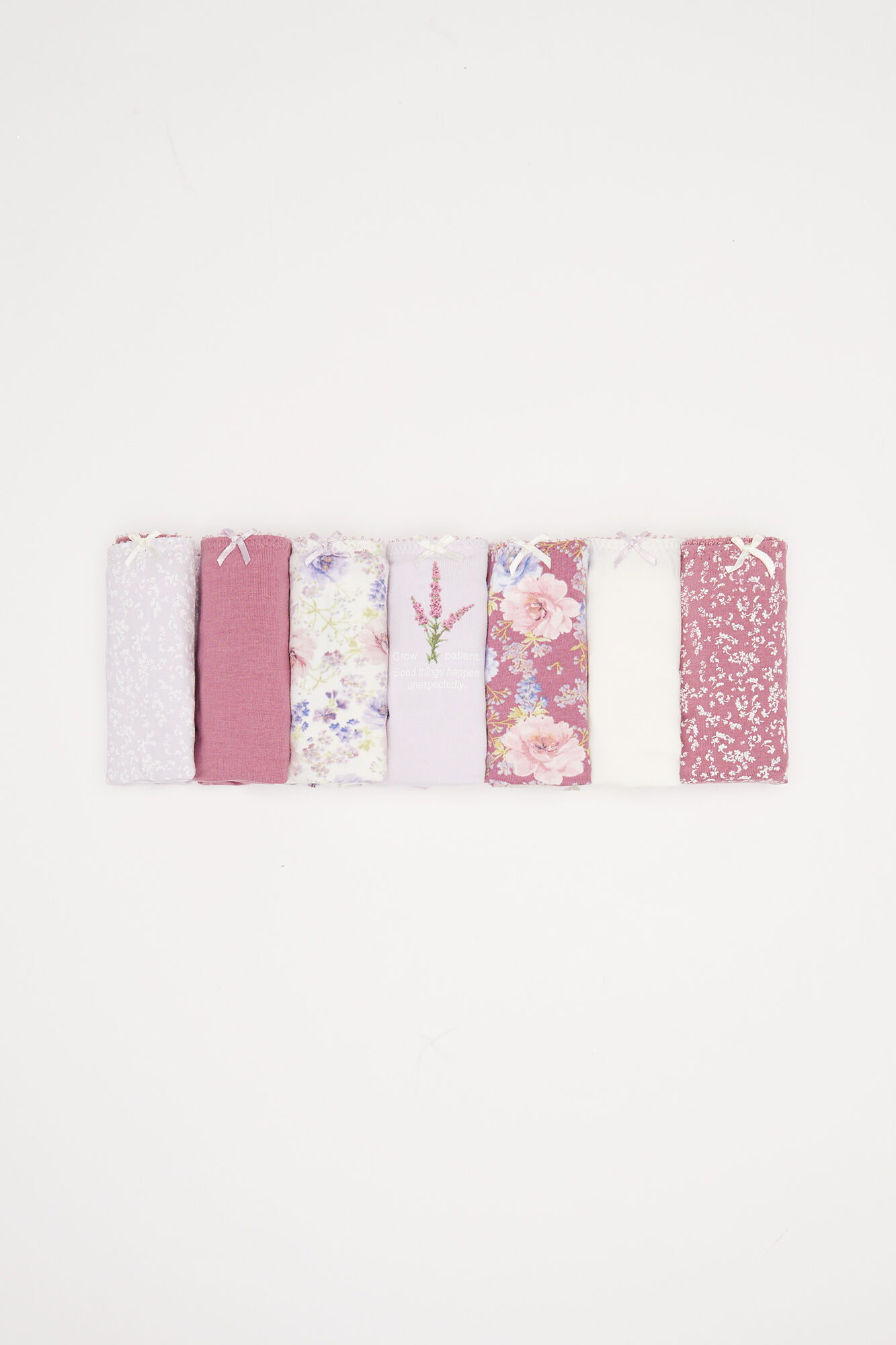Pacote com 7 calcinhas clássicas de algodão com estampa floral roxa.