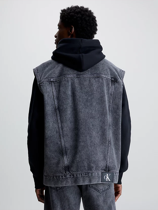 Colete jeans oversized com zíper frontal completo.