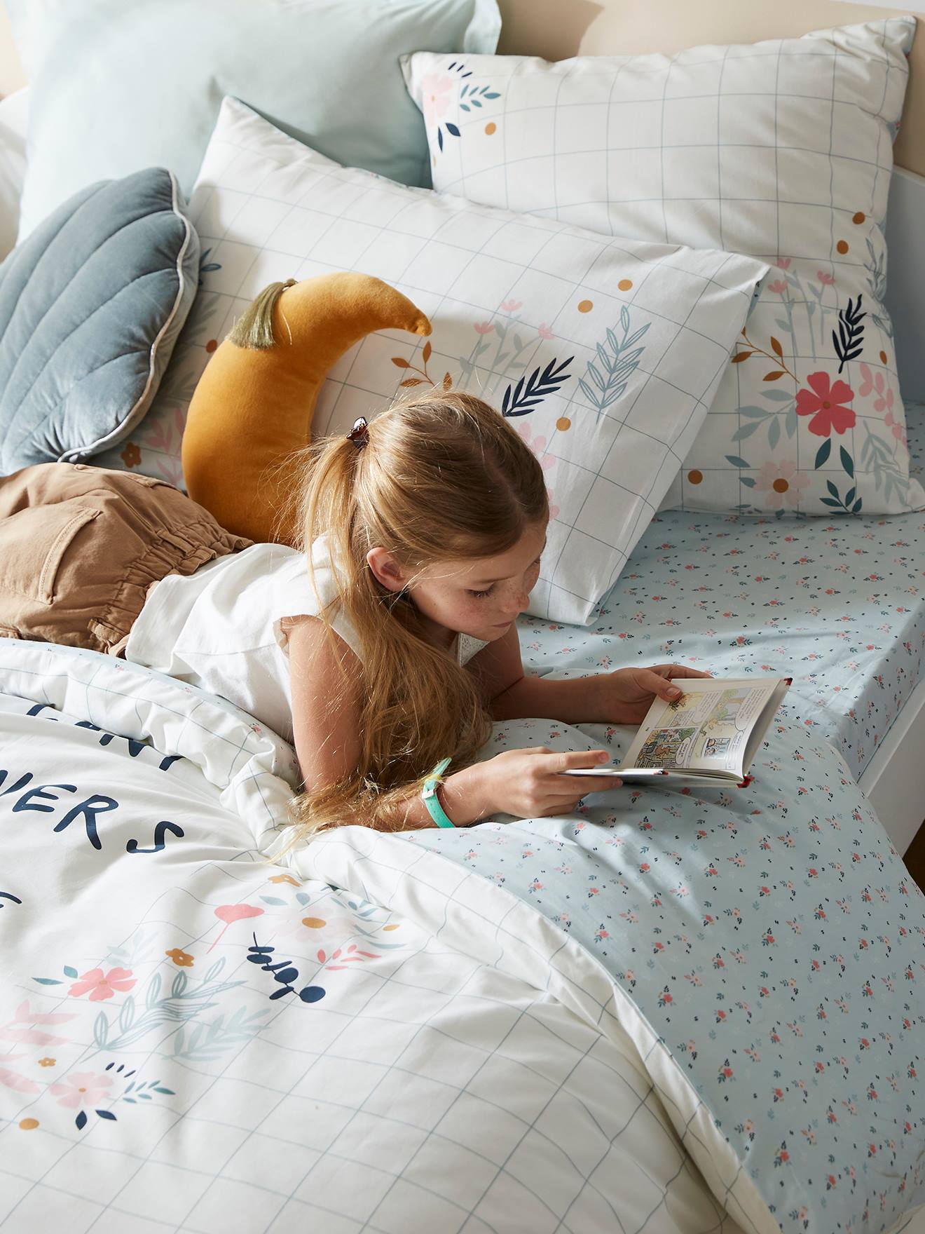 Conjunto de capa de edredom e fronha infantil em algodão orgânico, com estampa floral lisa em branco claro.
