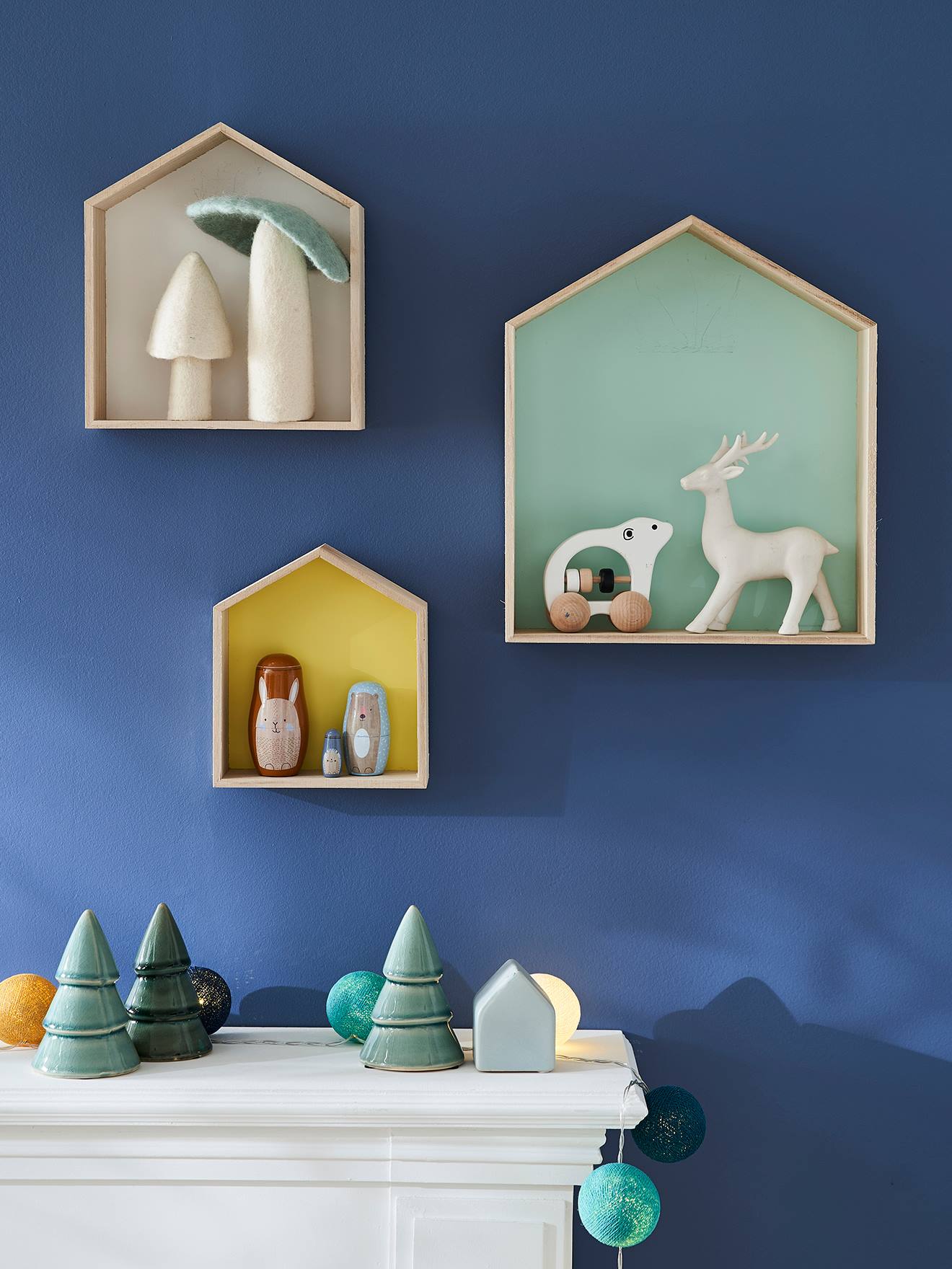 Conjunto de 3 prateleiras de madeira multicoloridas em formato de casa.
