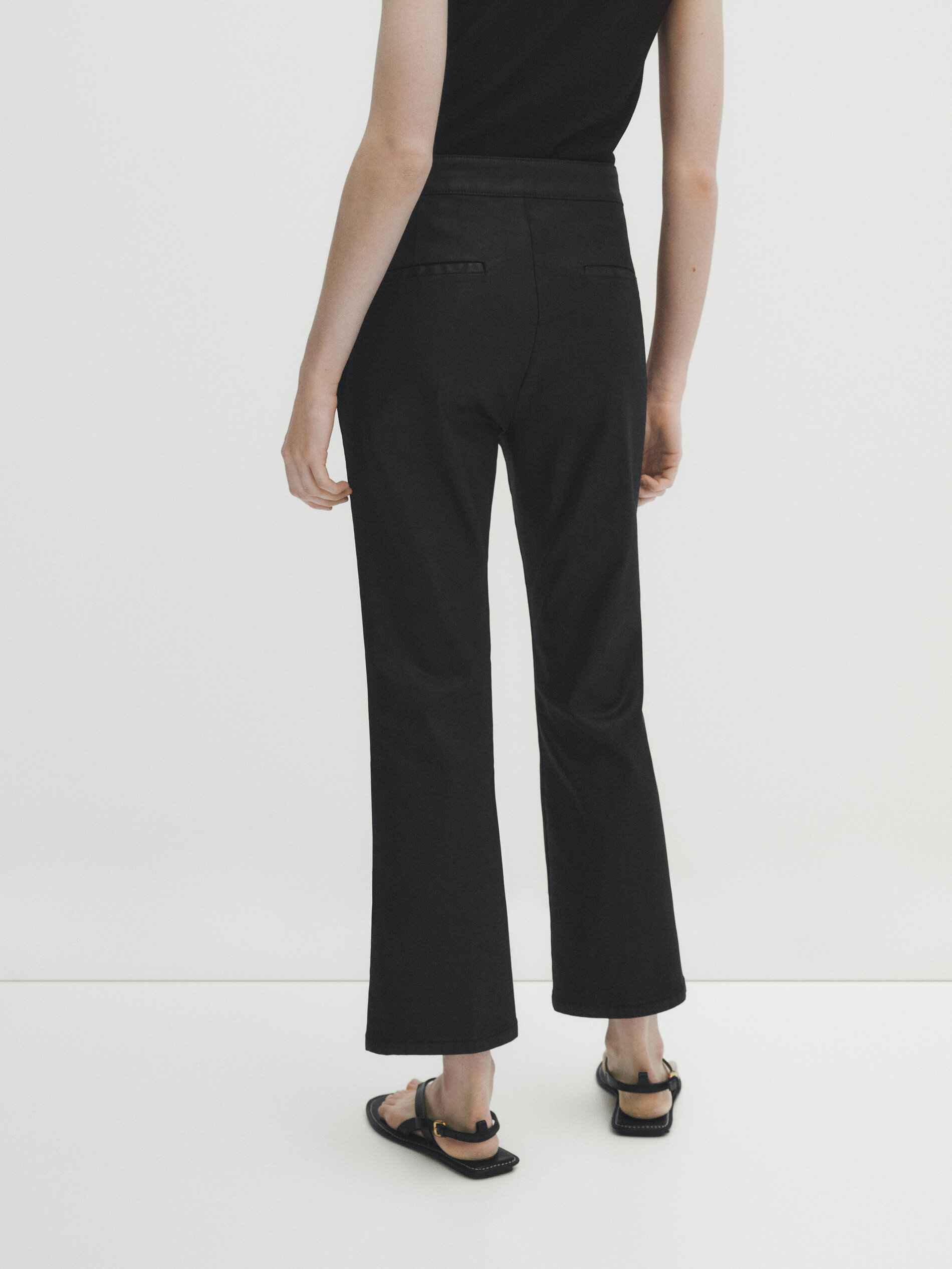 Calça flare com nervuras centrais e acabamento encerado - PRETA