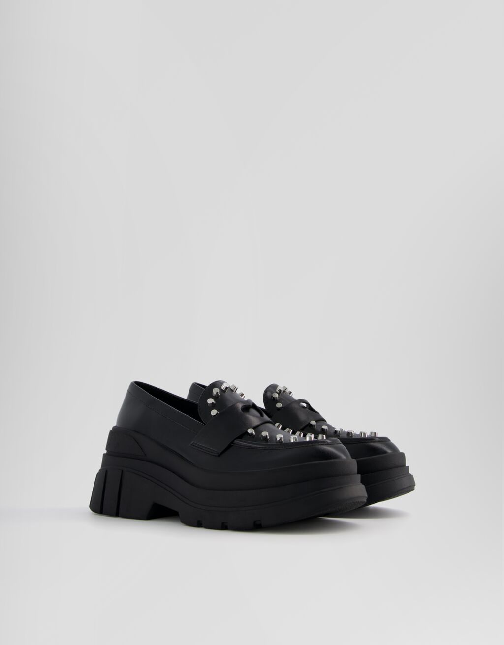 Mocassins com tachas e solado grosso.