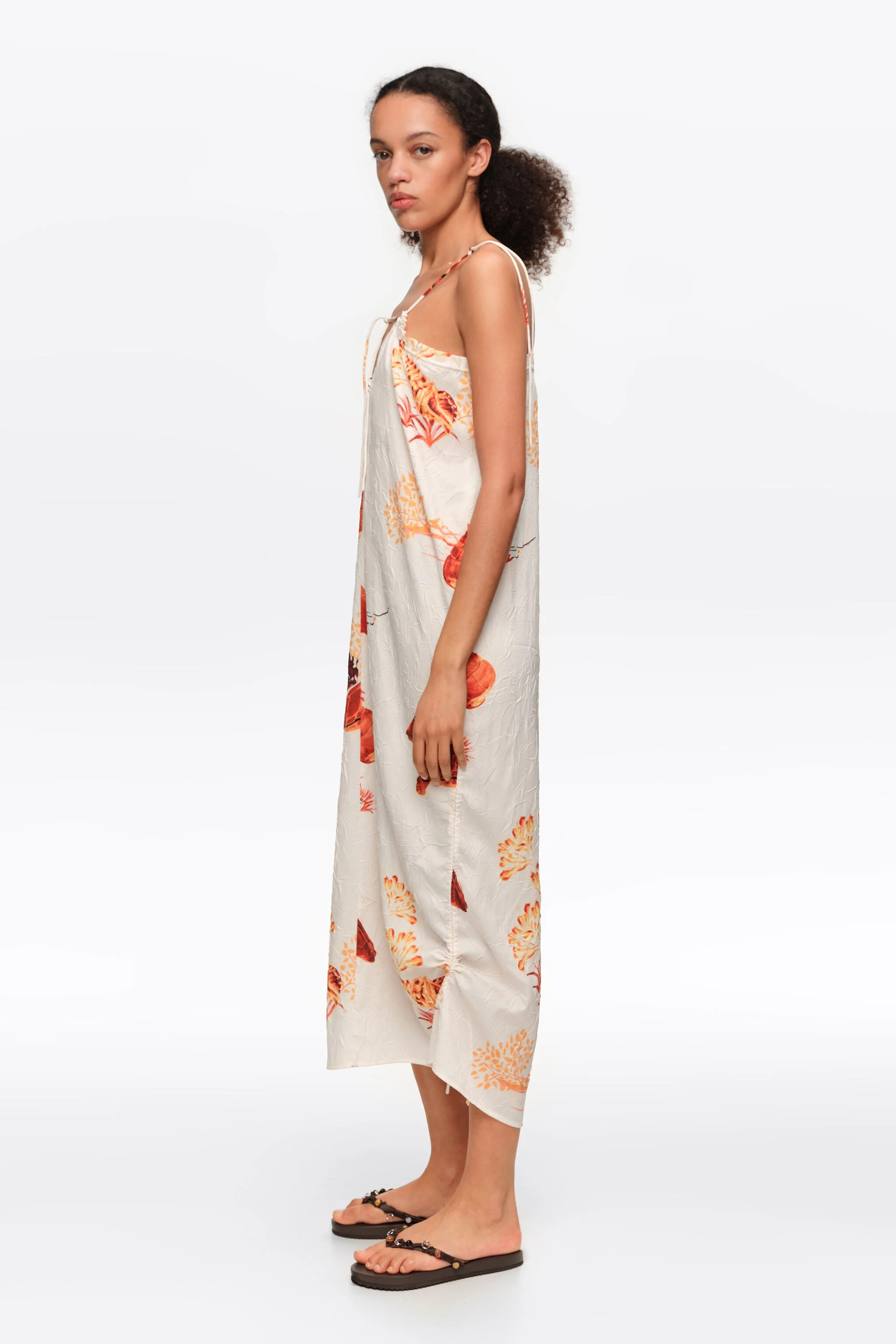 Vestido midi laranja com estampa de tartaruga e alças ajustáveis.