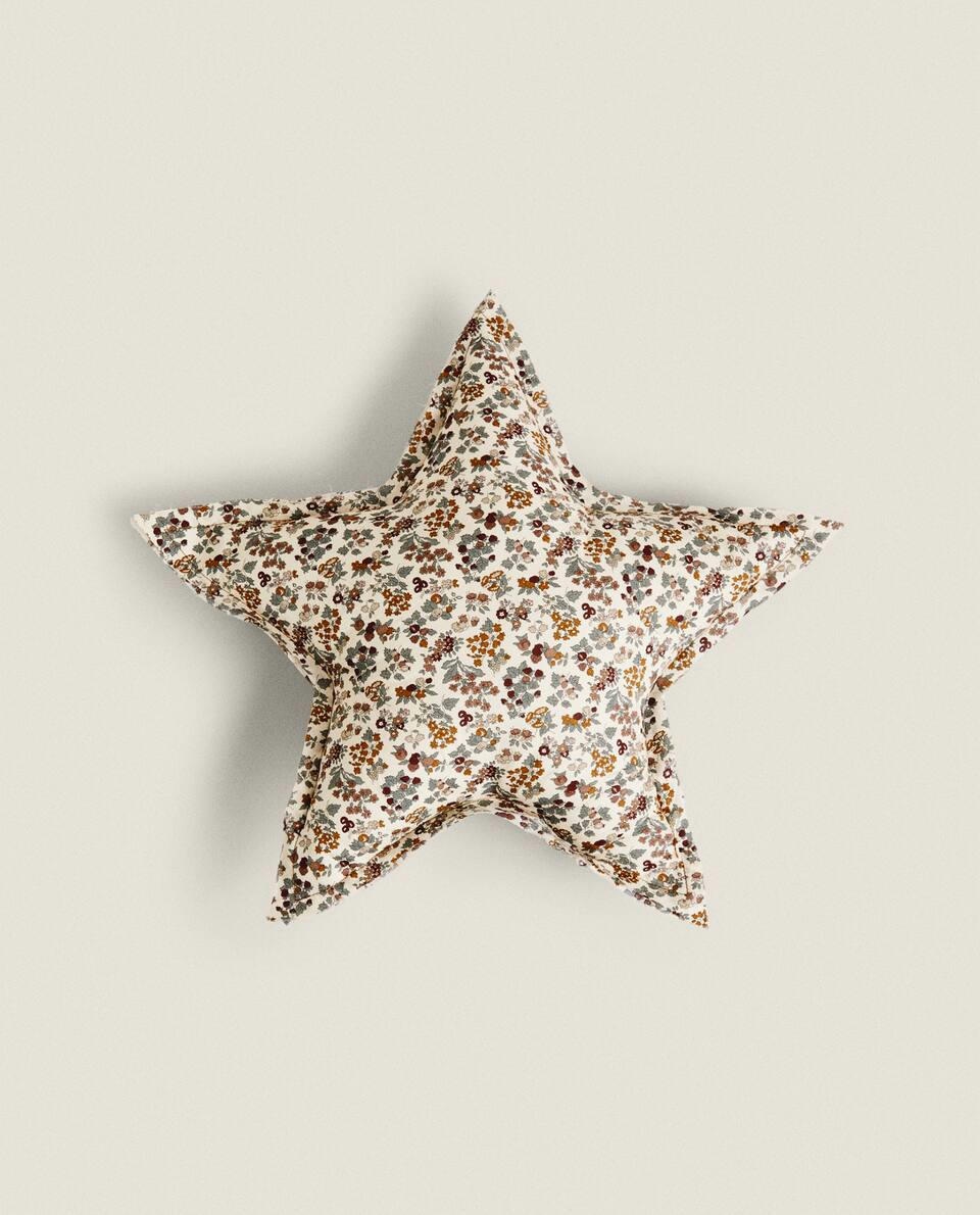 Almofada infantil em formato de estrela, em tecido com estampa floral.