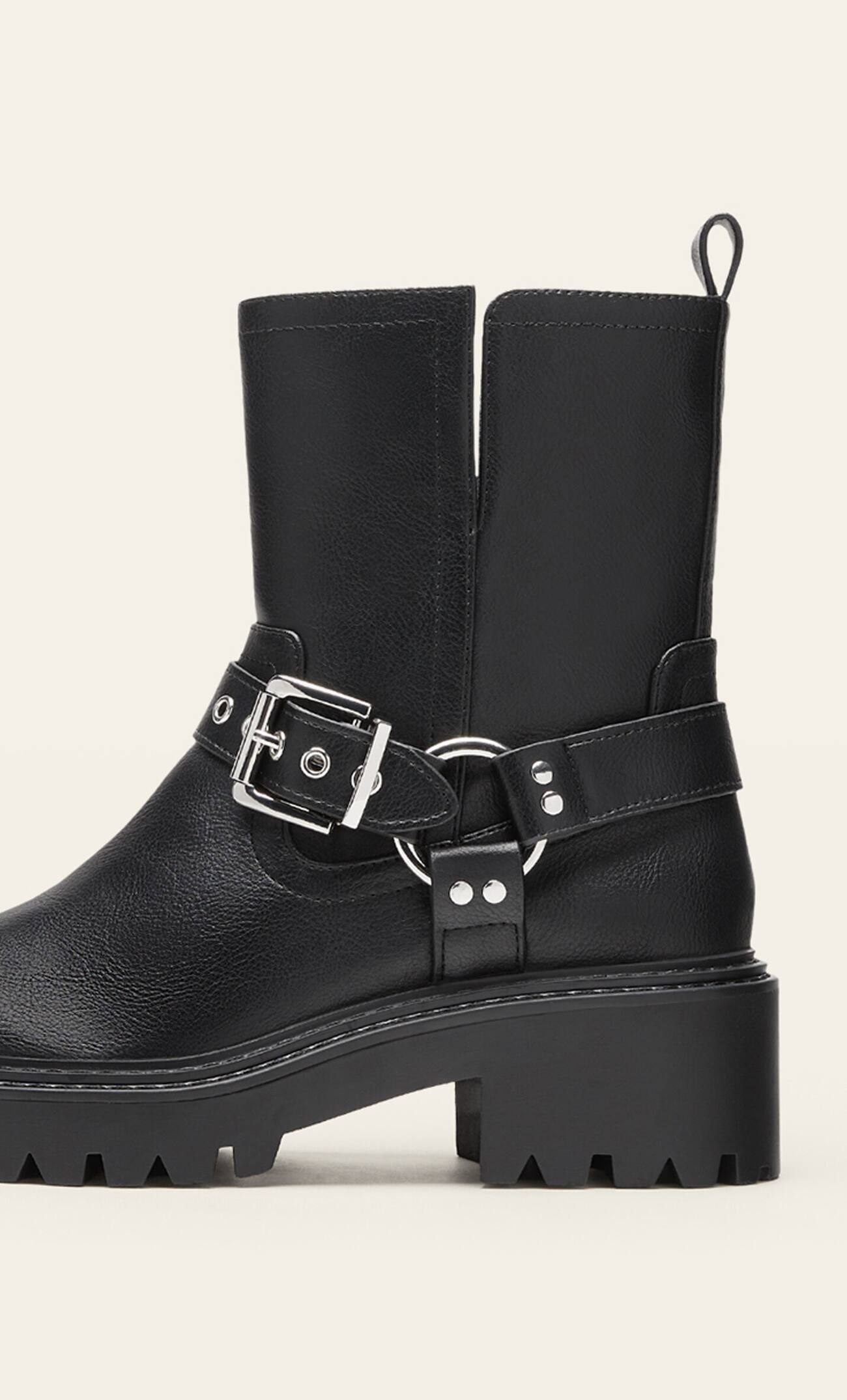 Botas de cano curto estilo motociclista, sem salto, com detalhes de fivela.
