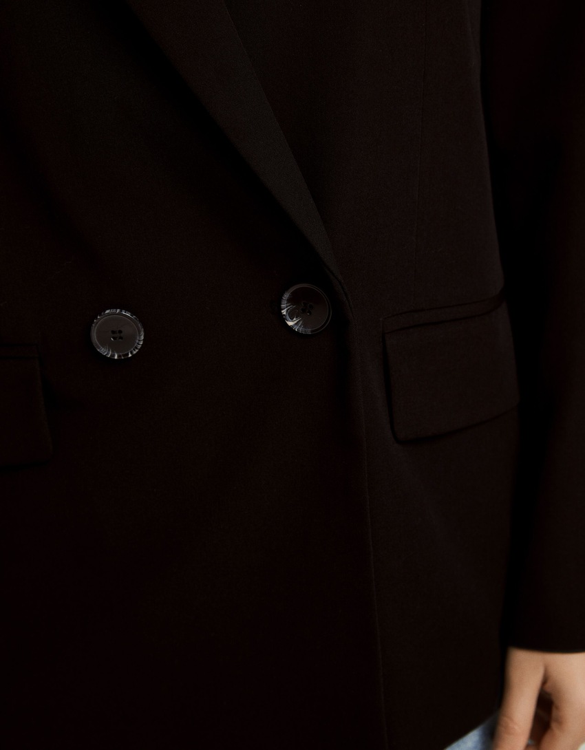 Blazer feminino de corte regular e abotoamento duplo.
