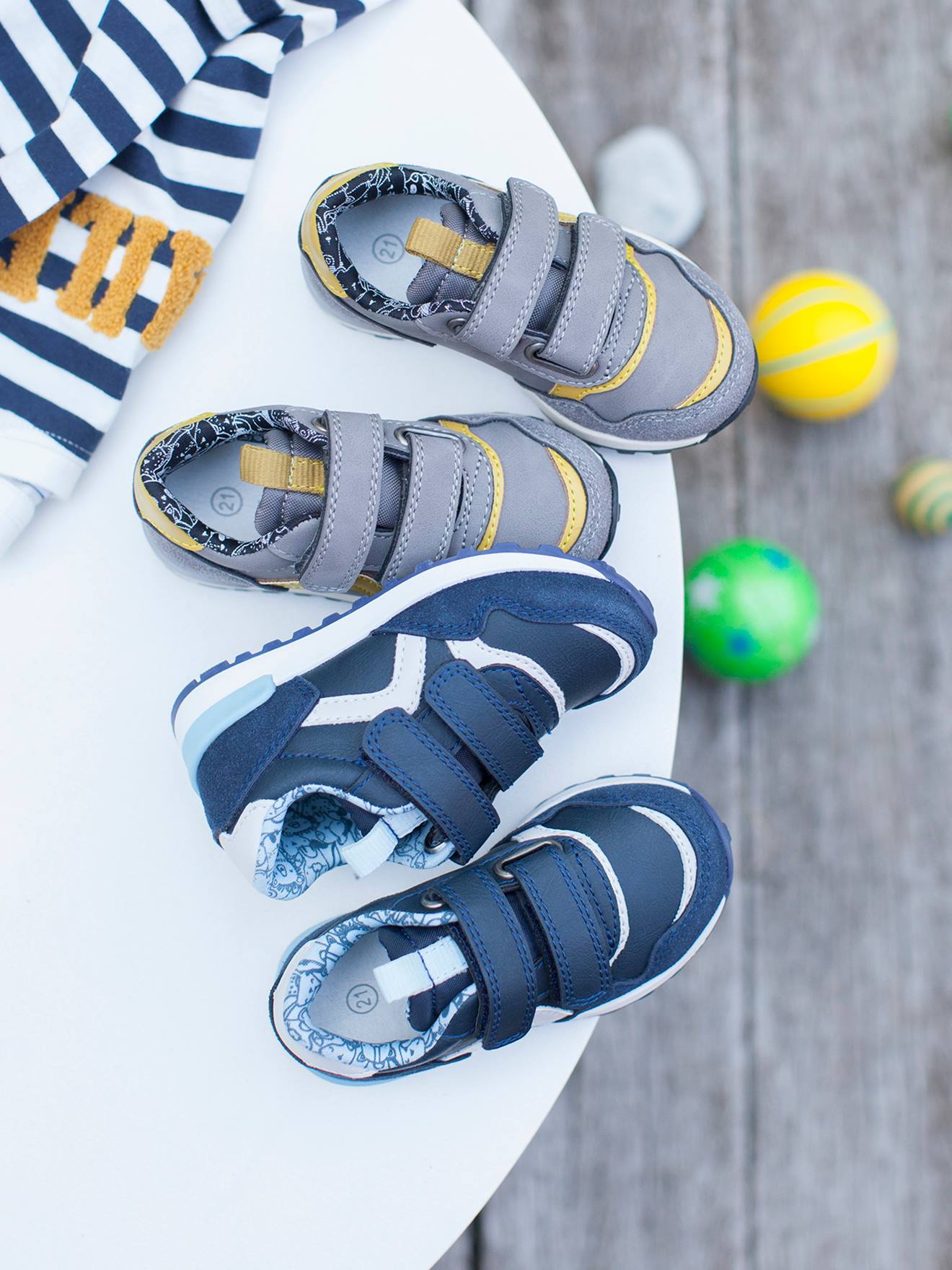 Tênis infantil estilo corrida com tiras autoadesivas, cinza médio, liso com detalhes.