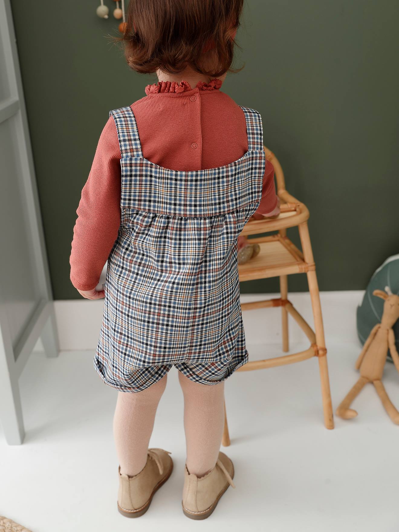 Conjunto para bebê: macacão xadrez, camiseta canelada lisa e faixa de cabelo rosa-claro combinando.