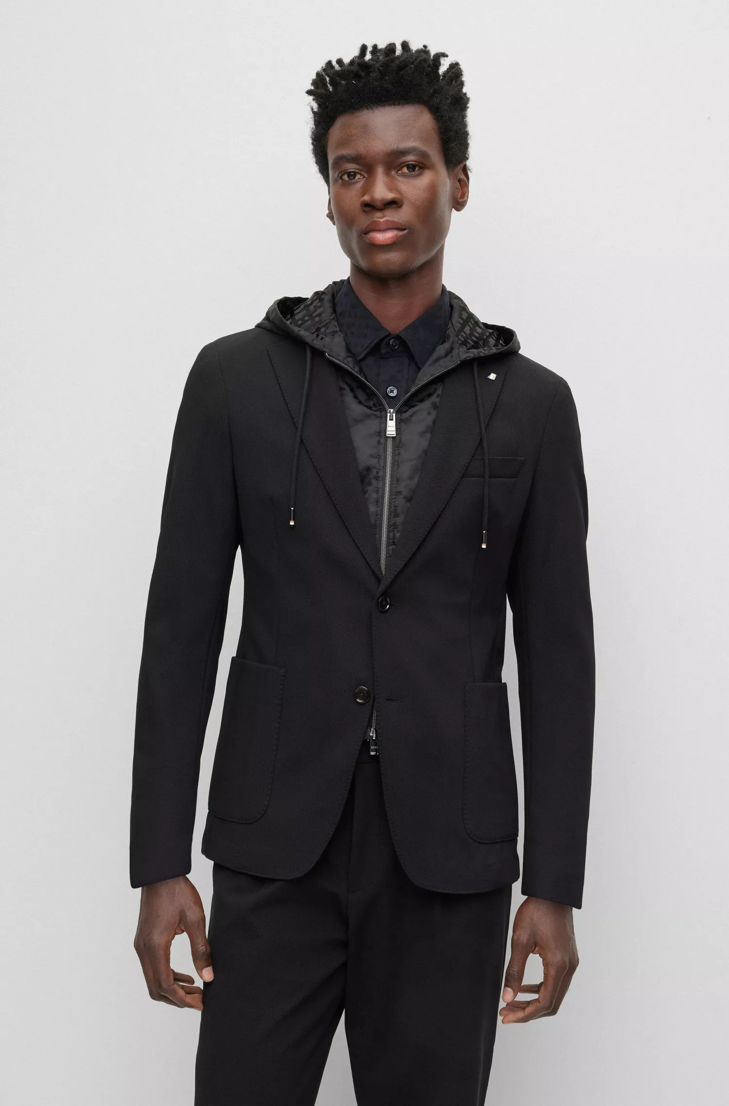 Jaqueta BOSS preta, corte slim, com capuz interno monogramado.