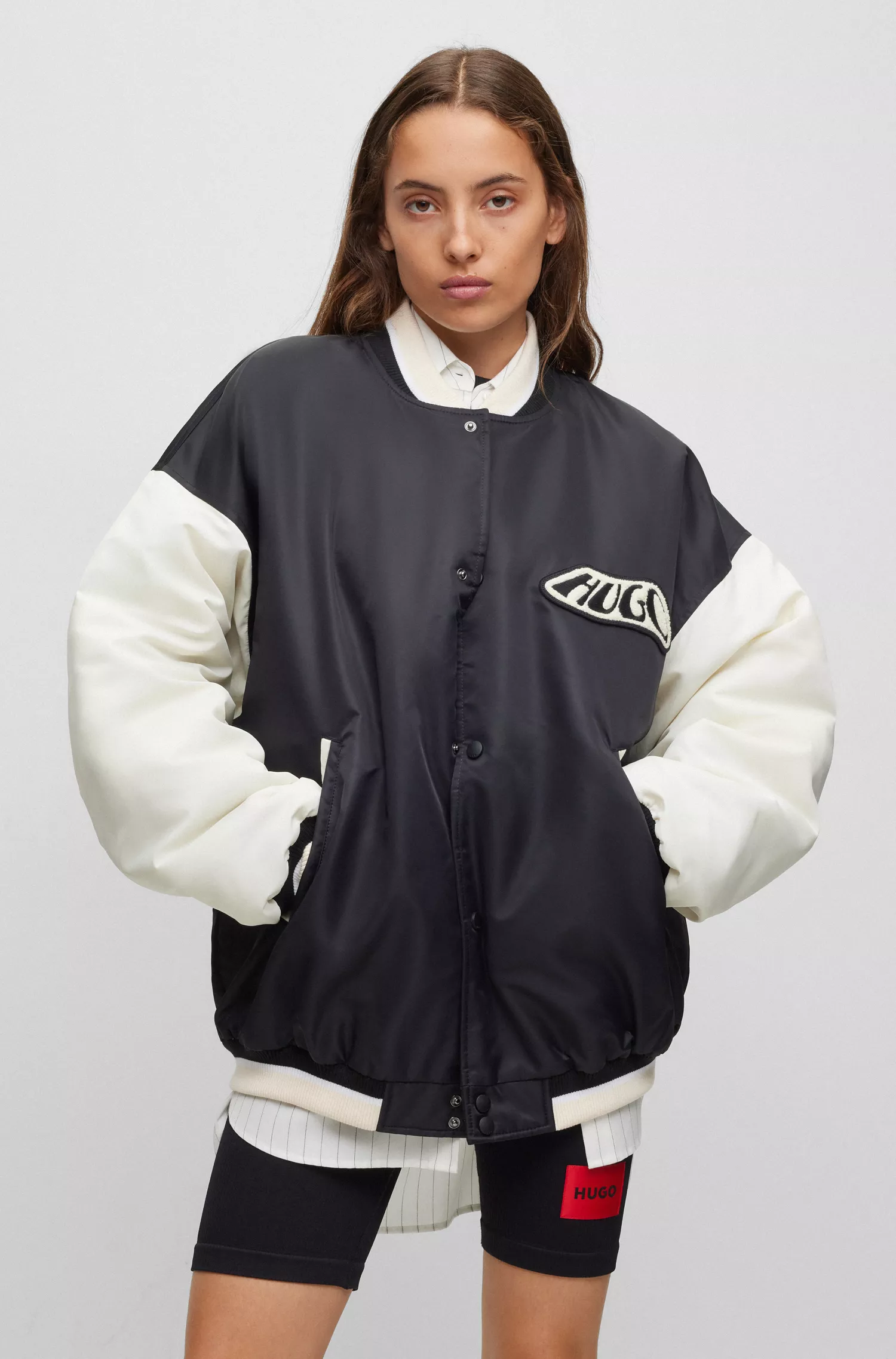Jaqueta bomber estilo universitário HUGO vermelha, repelente à água, com emblema da marca.