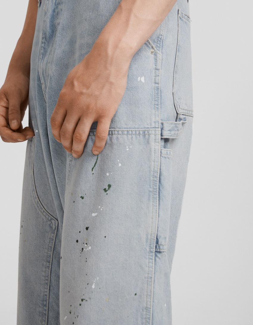 calça jeans de carpinteiro com respingos de tinta