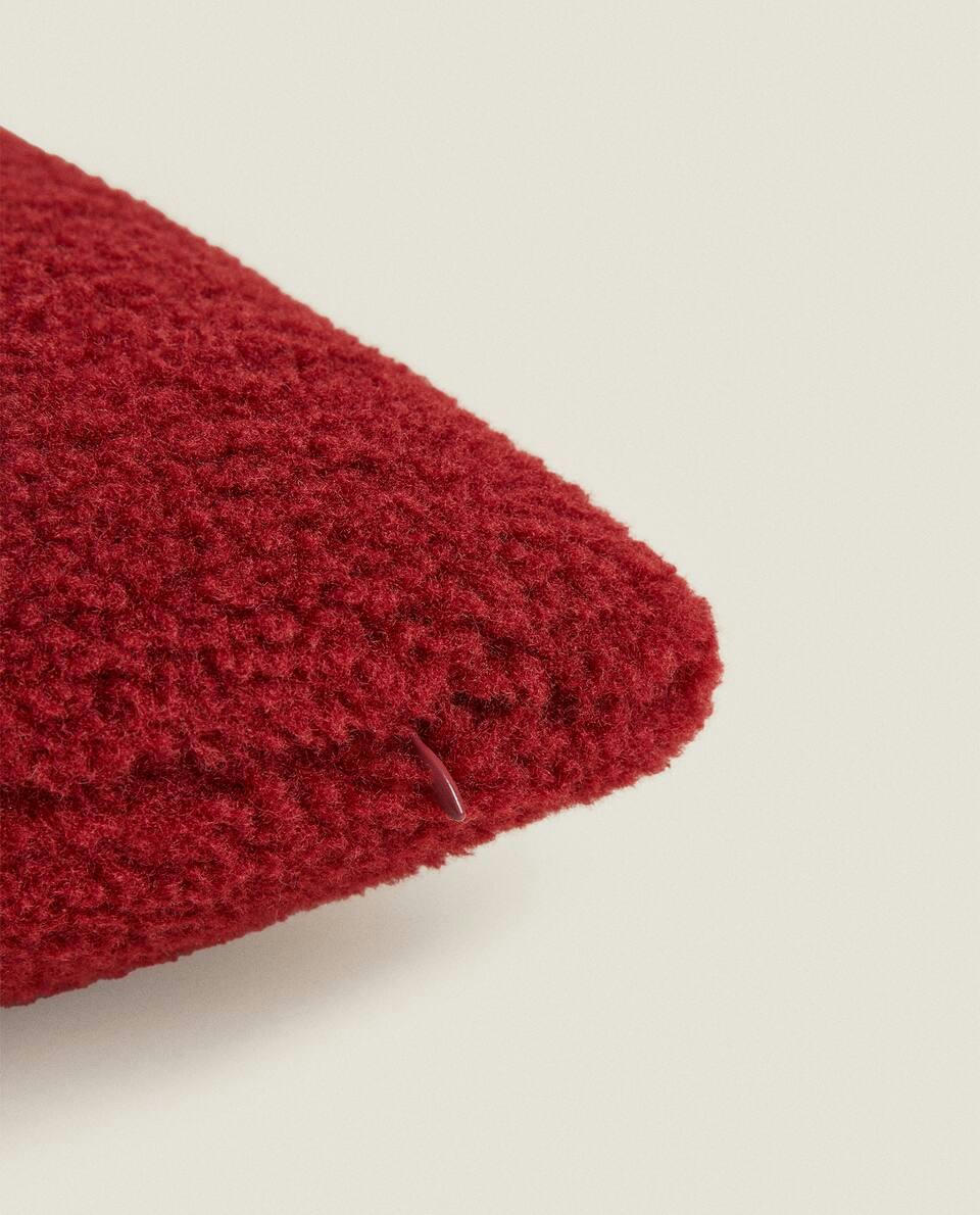 Capa de almofada natalina reversível em imitação de pele de carneiro.
