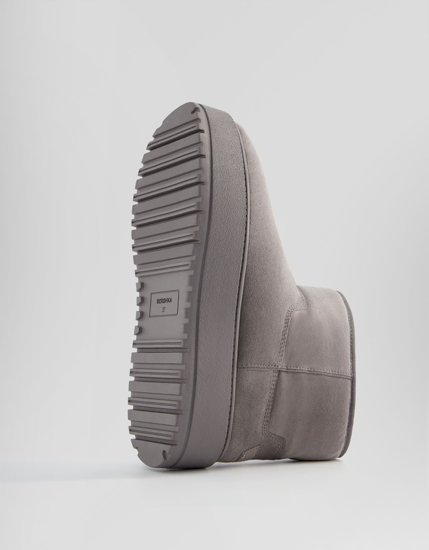 Botas de cano curto com plataforma e forro de pele sintética.