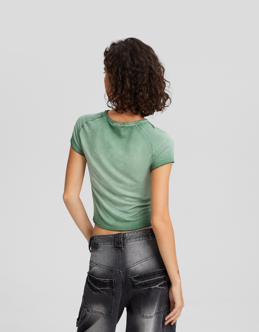 Camiseta de manga curta com efeito desbotado e aplicações de strass.