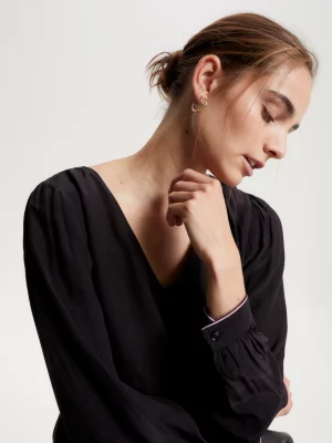 Blusa com decote em V, corte regular e detalhe de fita exclusiva.