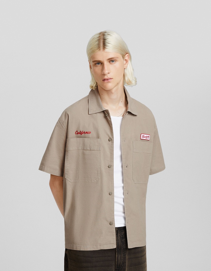 Camisa de trabalho de manga curta com aplicações.
