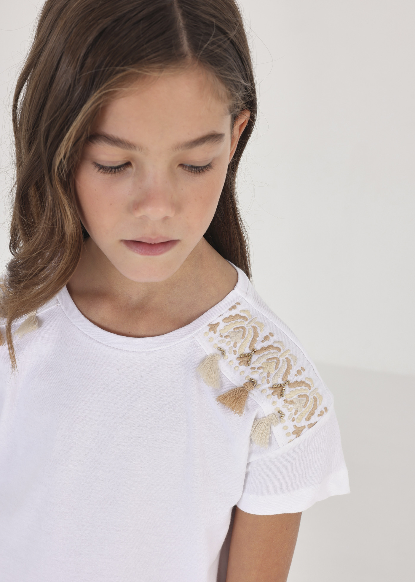 Camiseta infantil de manga curta com franjas, feita de algodão sustentável.