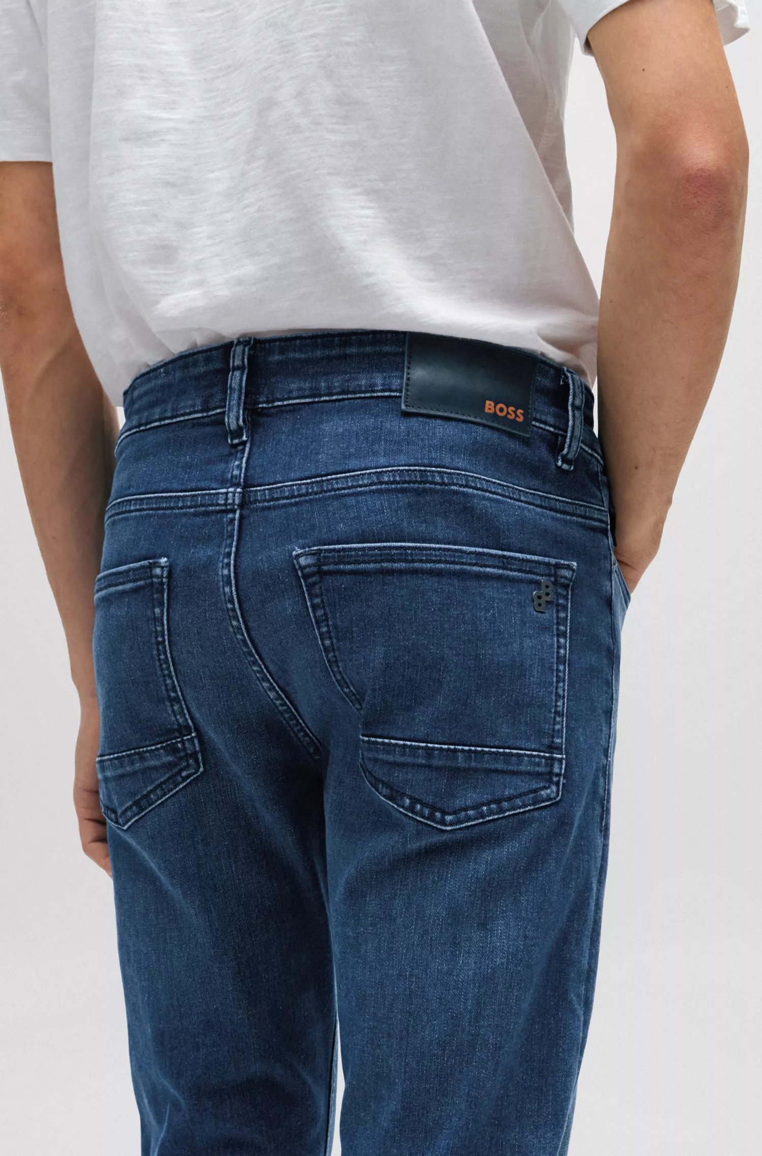 Calça jeans BOSS laranja, corte slim, em denim superelástico azul-escuro.