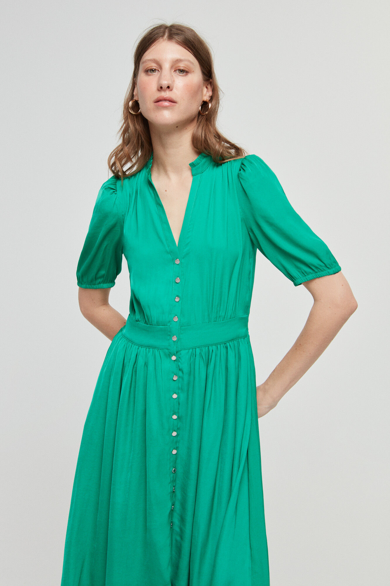 Vestido verde com mangas 3/4 e fechamento por botões.