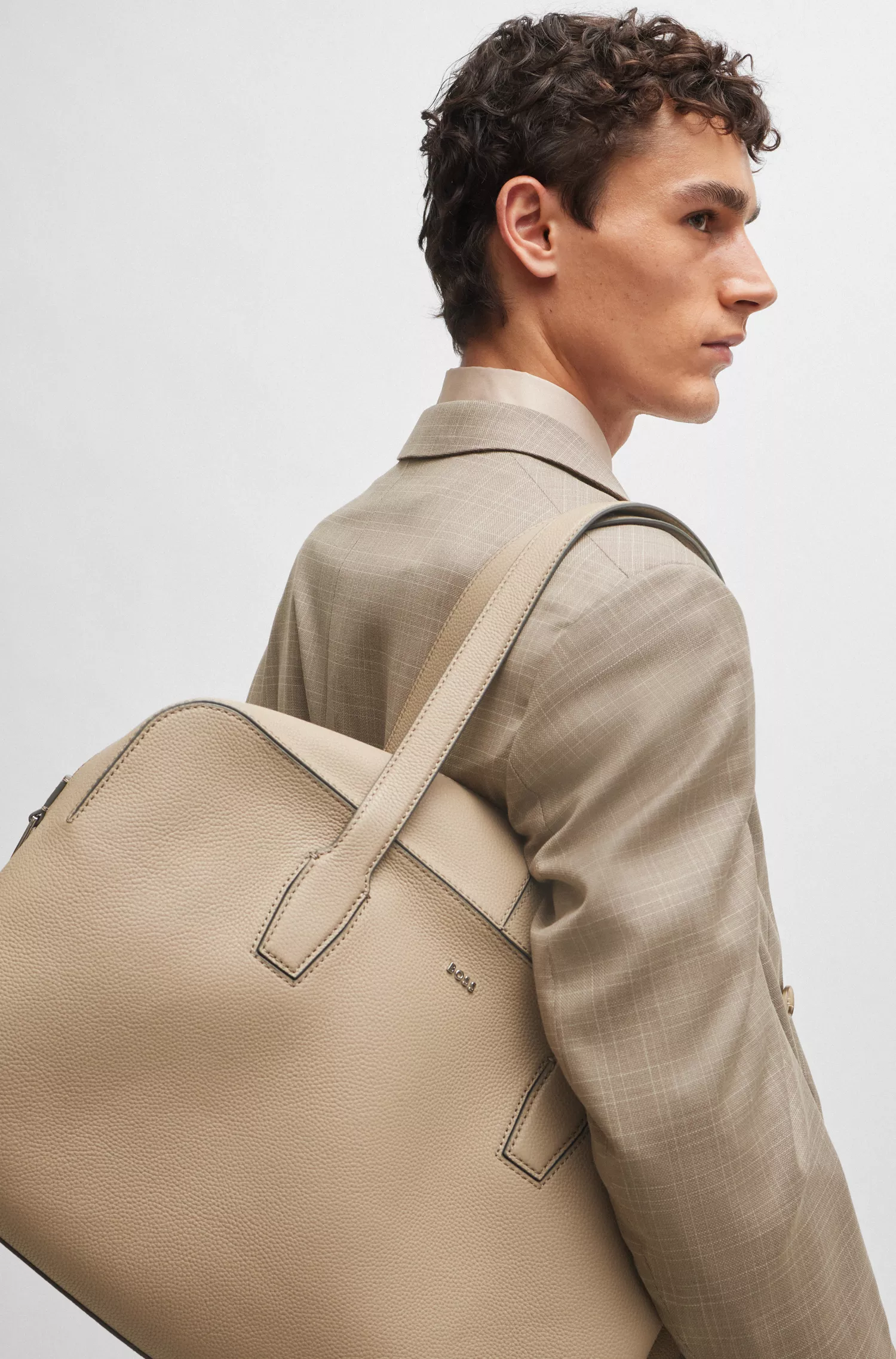 Bolsa de viagem BOSS preta com zíper, em couro granulado e com a inscrição do logotipo.