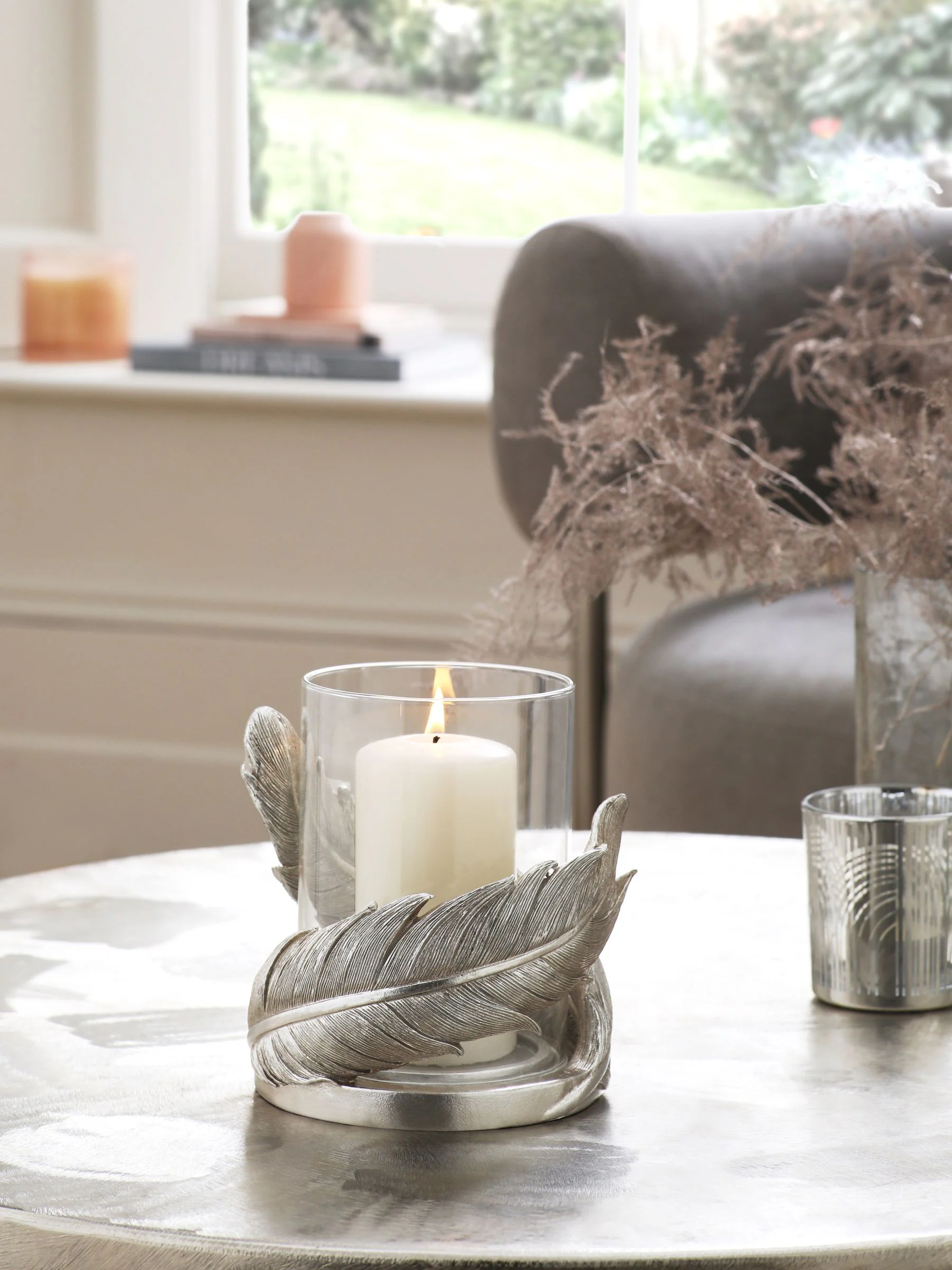 Windlicht van hars en glas met veren