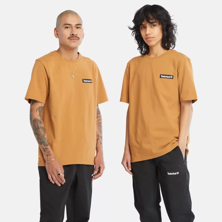 Camiseta unissex de tecido pesado com emblema na cor amarela.