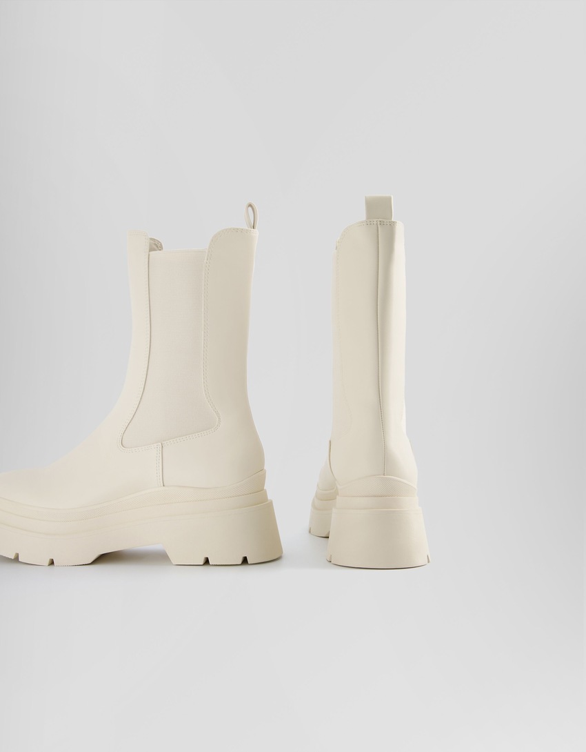 Botas de cano curto com elástico e sola tratorada.