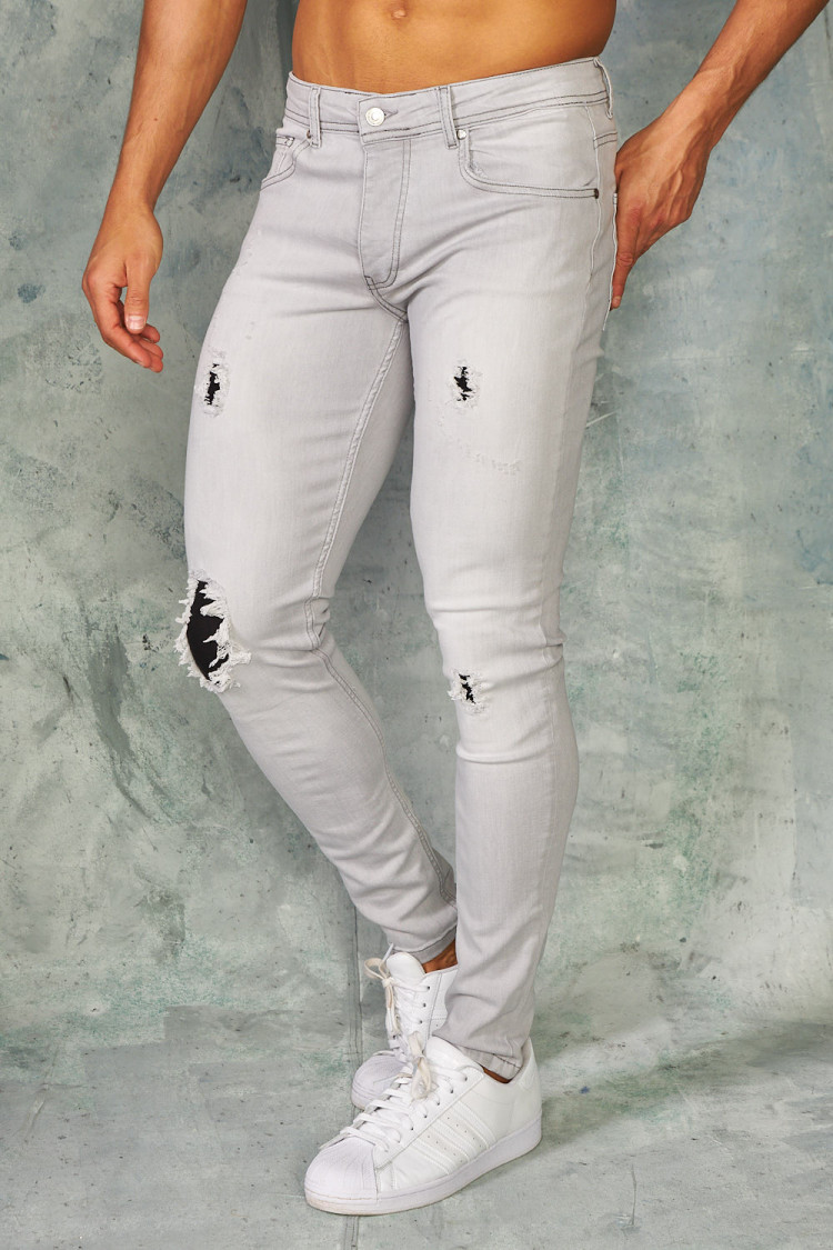 Jeans slim gris déchirures doublées noires