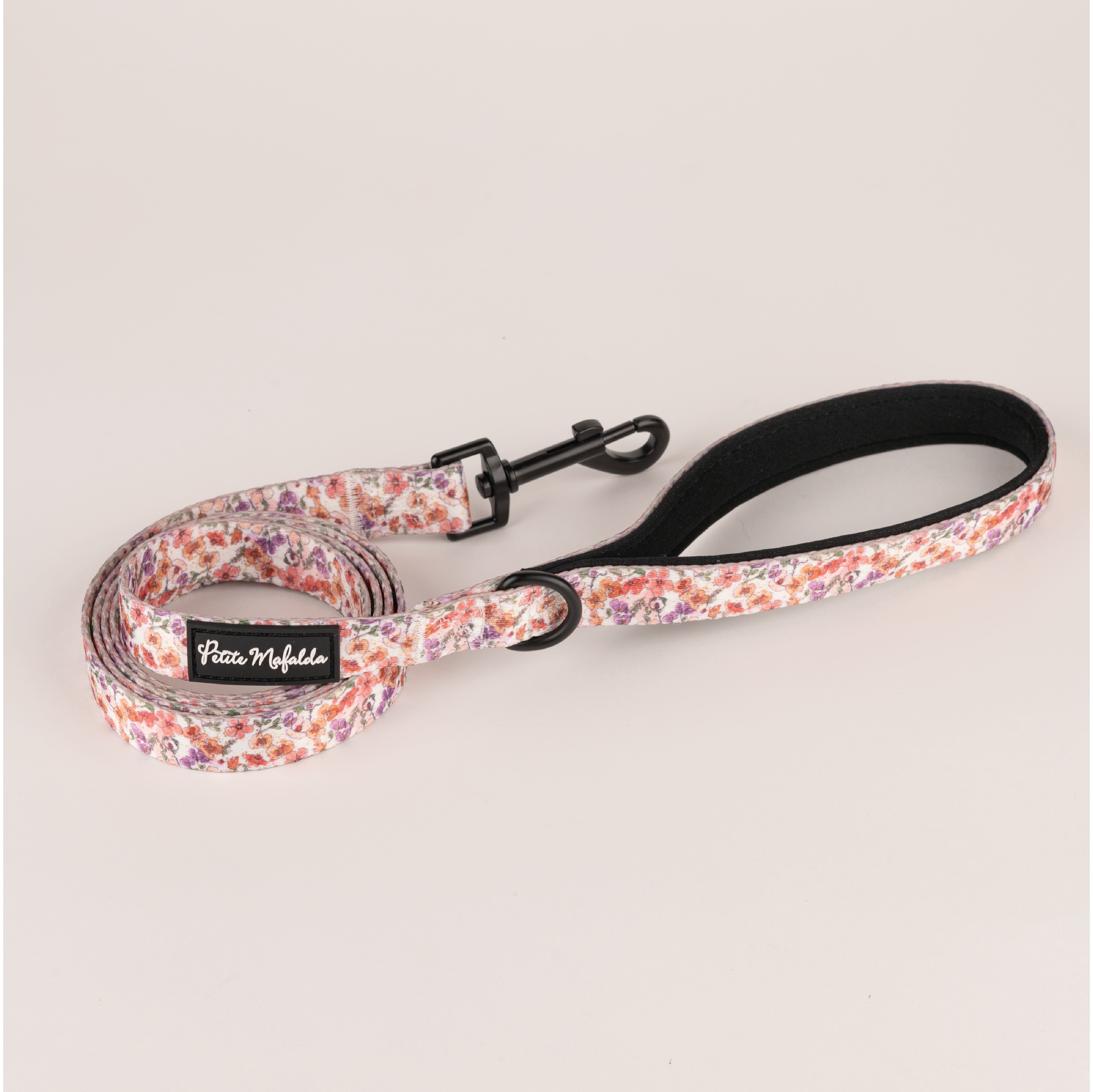 Conjunto Petite Mafalda com coleira, guia e porta-bolsas com estampa floral rosa para cães.