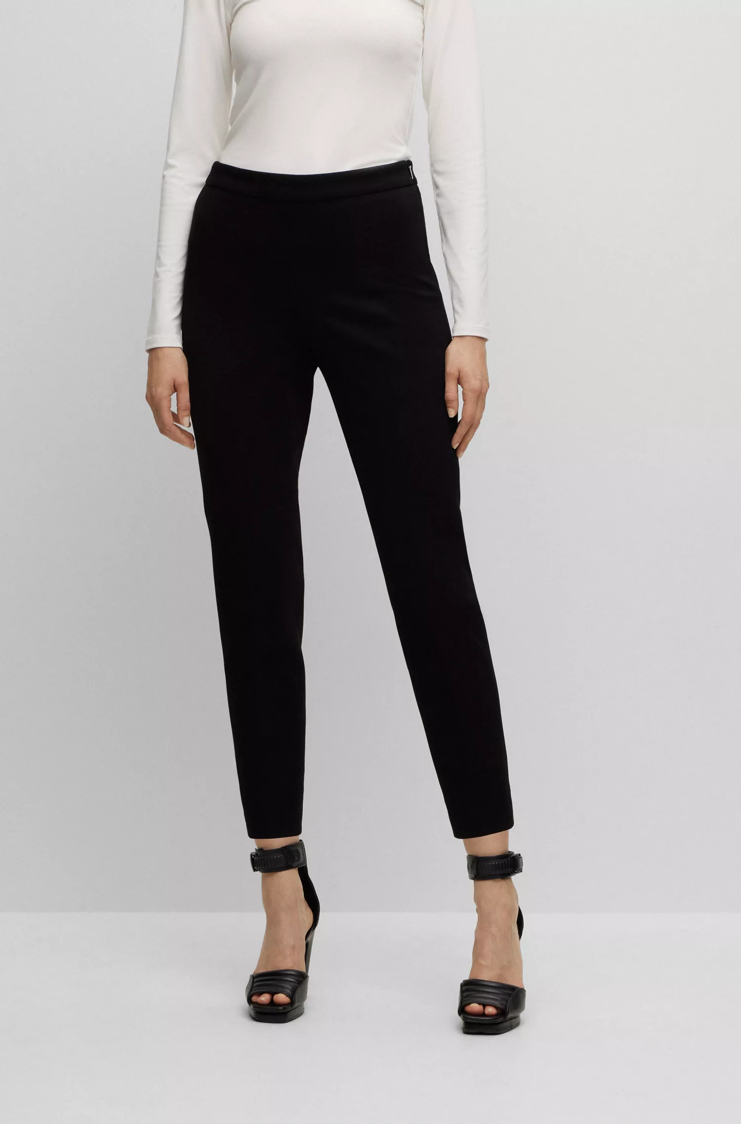 Calça BOSS preta, corte regular, em tecido elástico com pernas afuniladas.
