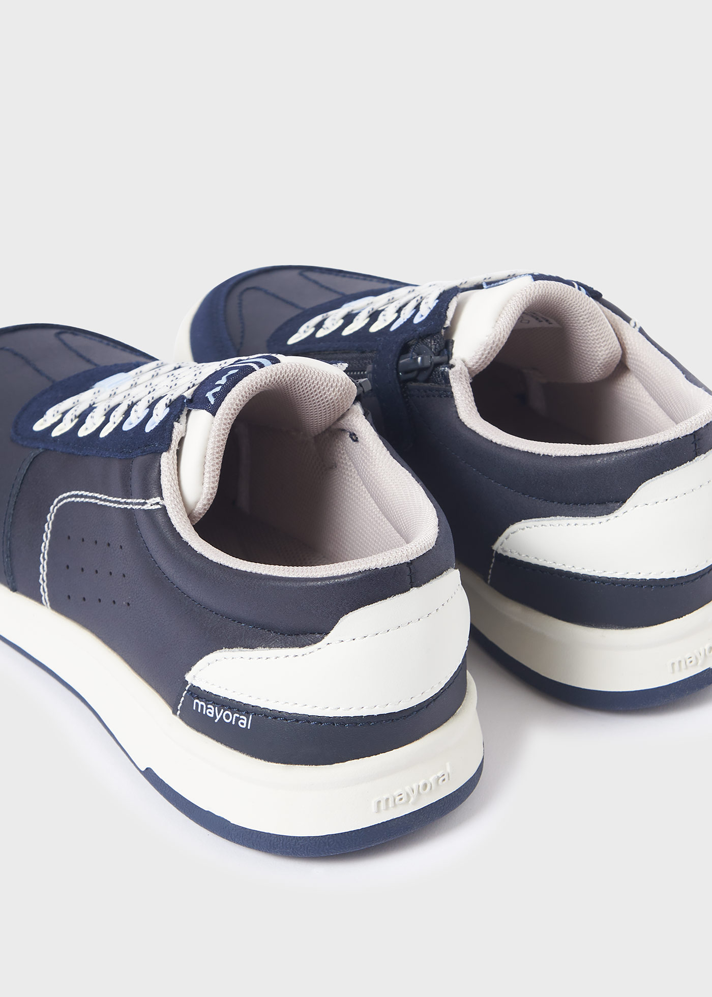 Jaqueta esportiva infantil com zíper lateral e detalhes perfurados.