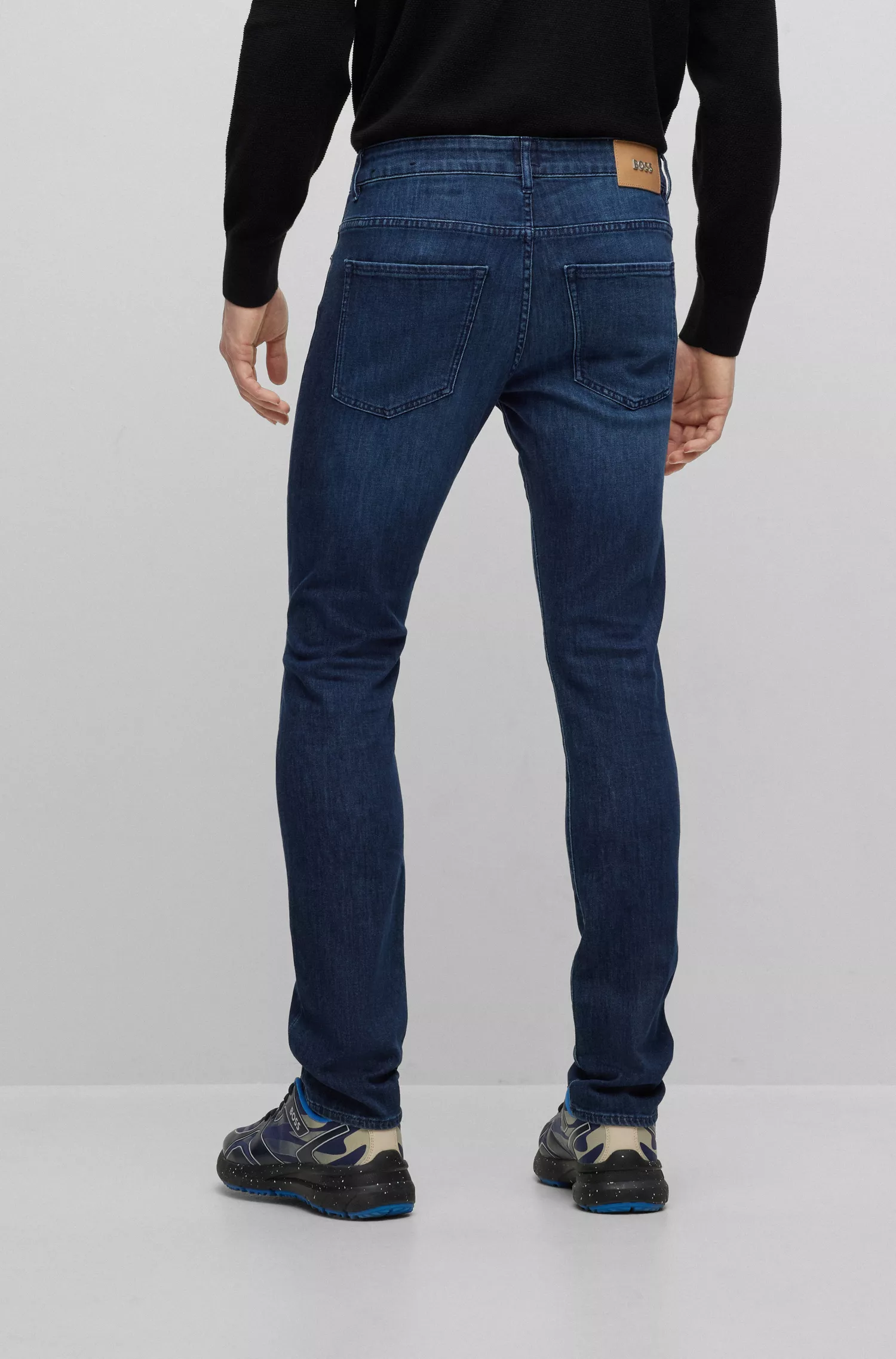 Calça jeans BOSS preta, corte slim, em denim italiano leve azul-escuro.