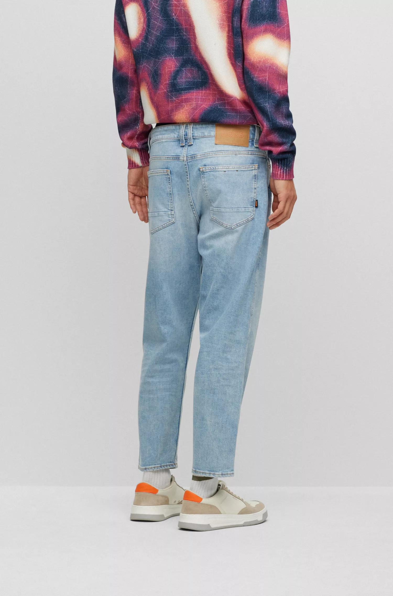 Calça jeans BOSS laranja, corte afunilado, em denim azul com elasticidade confortável.