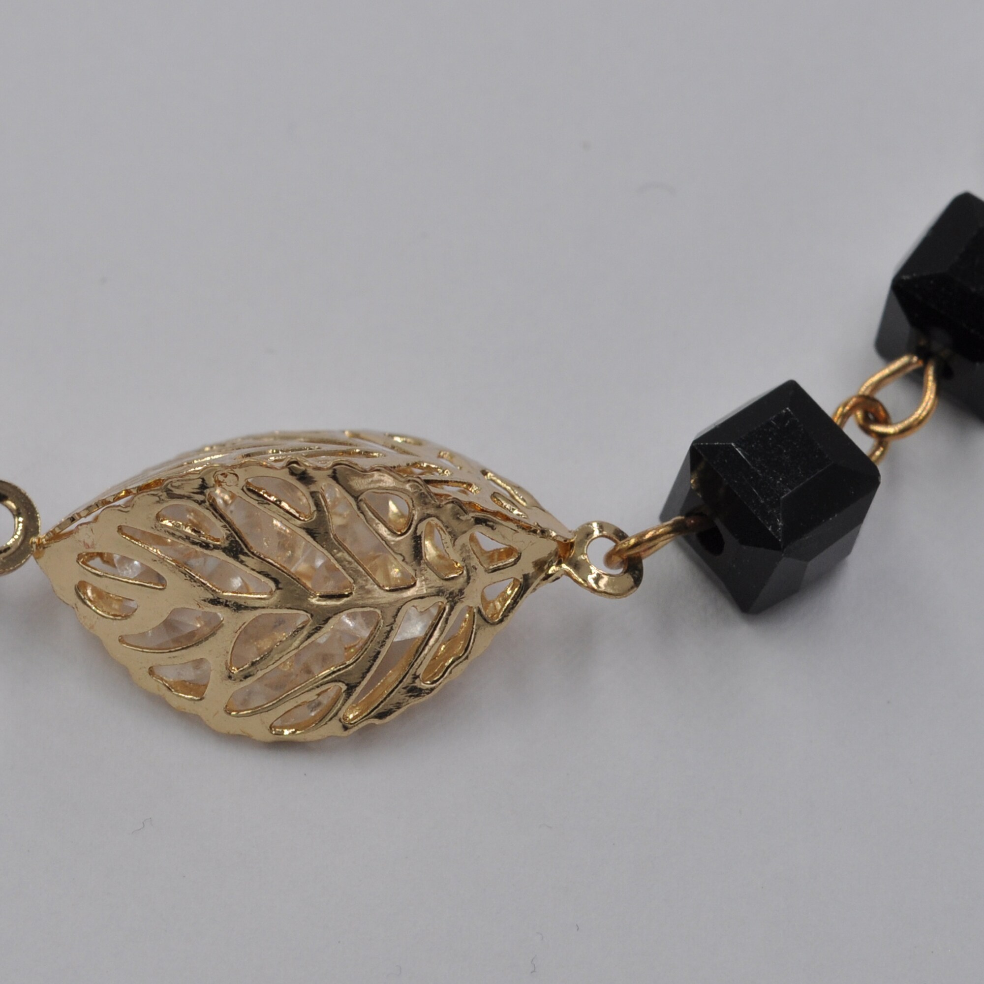 Steuer Modeschmuck Kette Kette aus Glaswürfeln schwarz mit goldfarbener Blattzierde