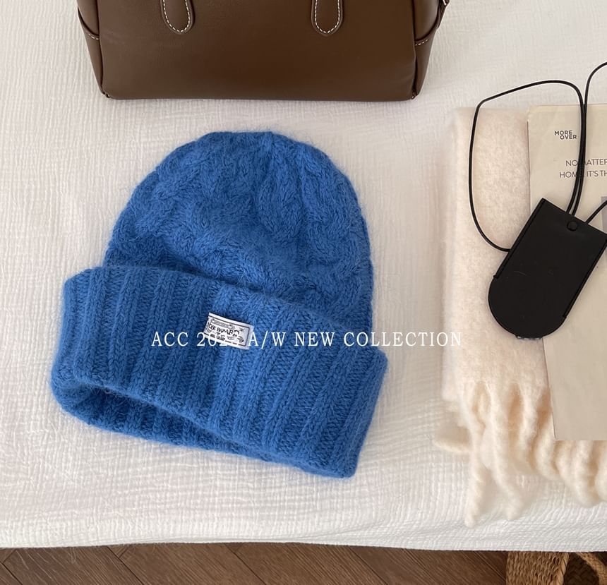 Combon - Gebreide kabelmuts met appliqué