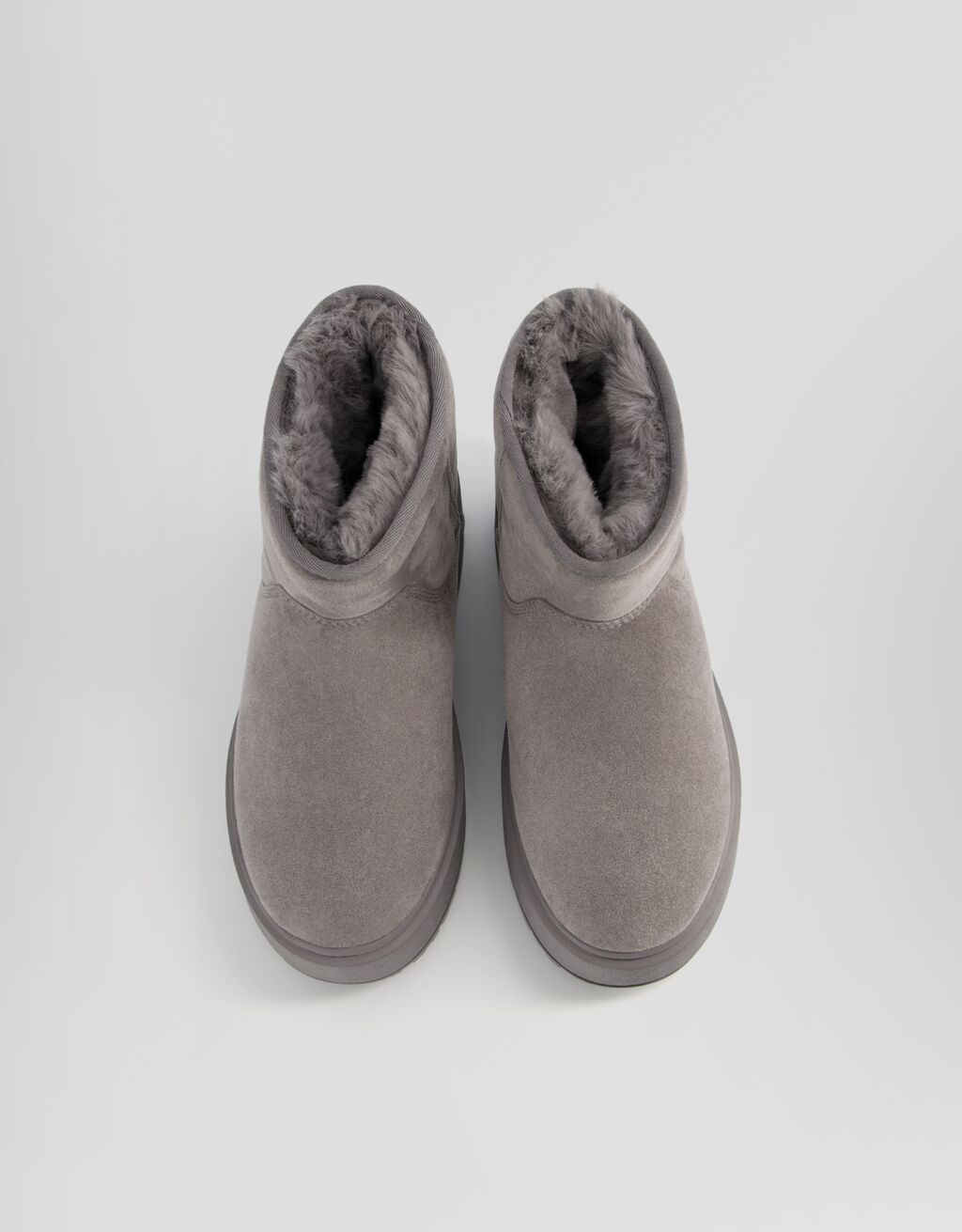 Botas de cano curto com plataforma e forro de pele sintética.