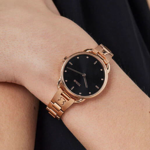 Relógio analógico com pulseira em aço/IP rosa e mostrador preto.