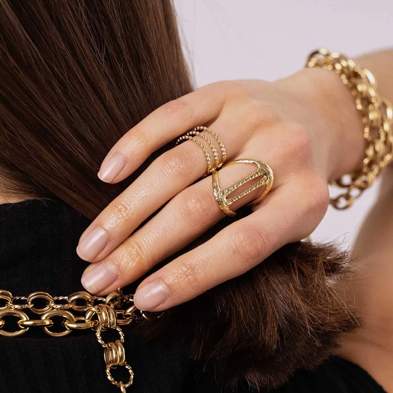 Bague ajustable en acier doré composée de formes géométriques ajourées et texturées