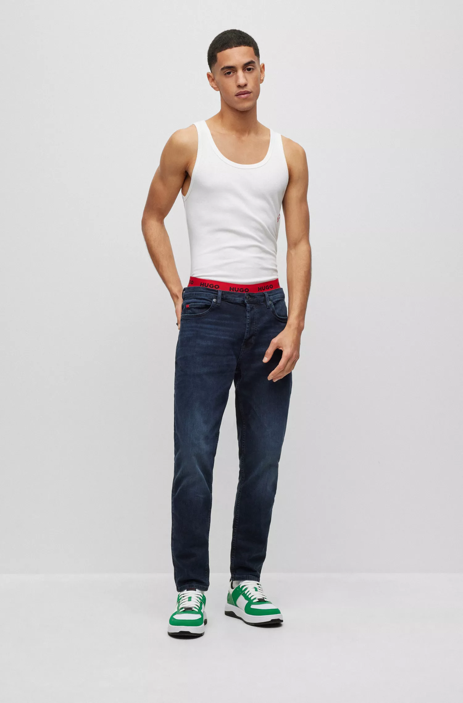 Calça jeans HUGO vermelha, corte afunilado, em denim azul-escuro.